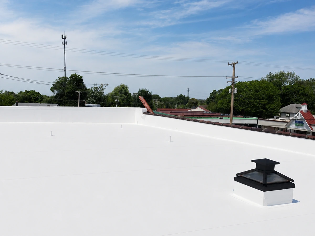 Completed white TPO flat roof installed by ASAP Roofing & Contracting in Baltimore, MD, showing heat-welded membrane surface and black skylight curb detail