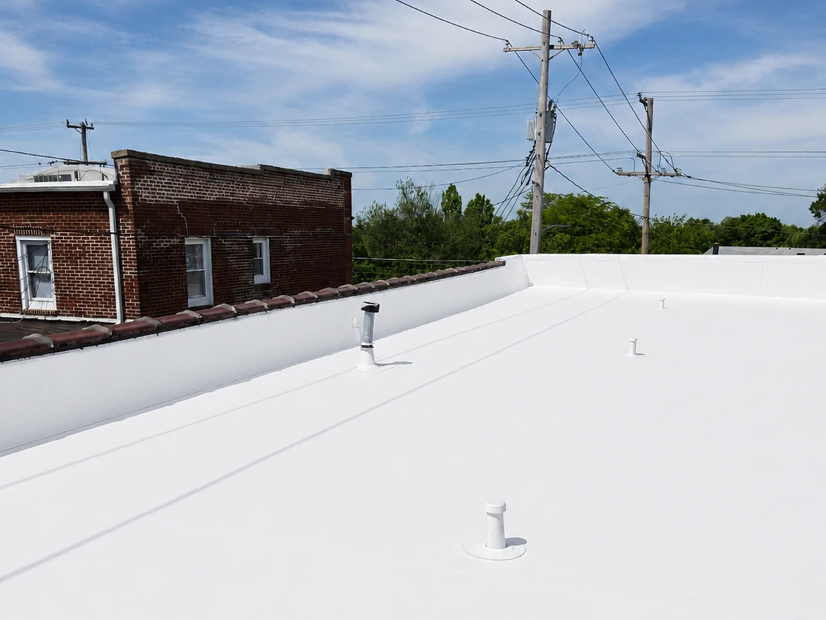 TPO flat roof installation by ASAP Roofing & Contracting in the Baltimore, MD area, showing clean membrane field adjacent to brick neighboring structure
